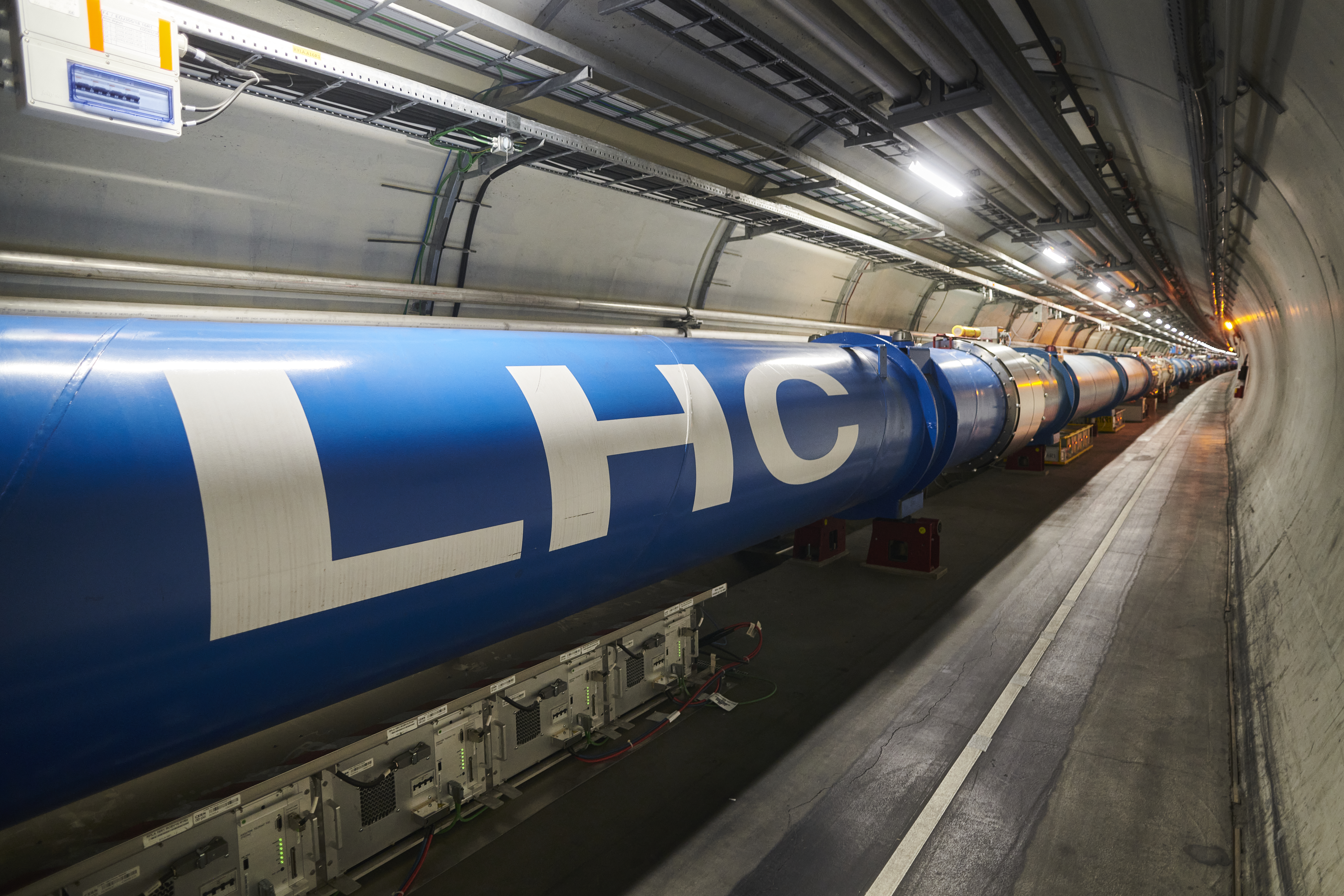 LHC tunnel interior showing the blue dipole magnets stretching into the distance